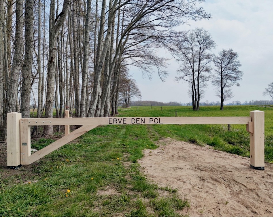 houten poort met de naam erin gefreesd en de letters zijn zwart gemaakt.